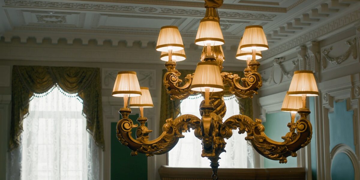 Veliki klasiฤni luster sa viลกe abaลพura postavljen u raskoลกnoj prostoriji, primer lustera koji moลพe delovati preteลกko ili neprilagoฤeno manjem prostoru.