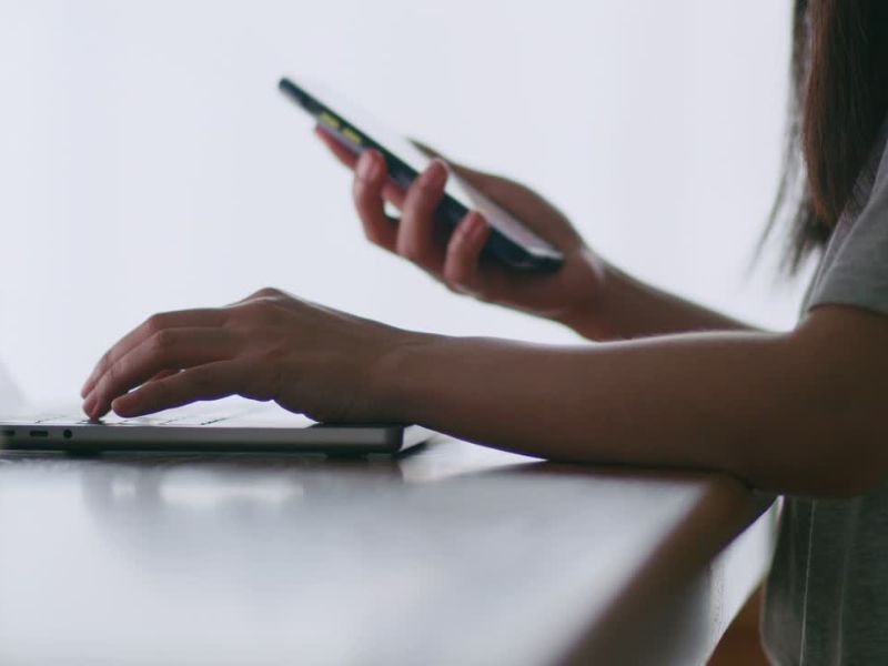 osoba koristi laptop i telefon