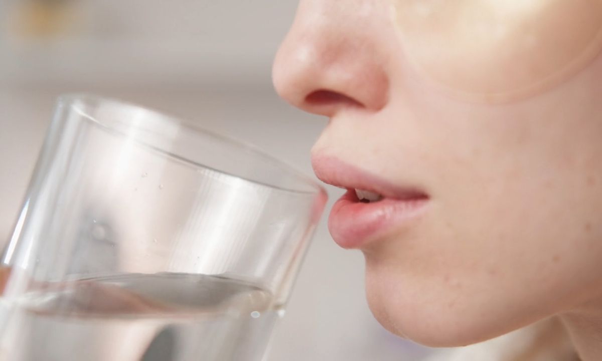 devojka pije mlaku vodu sa limunom na prazan stomak