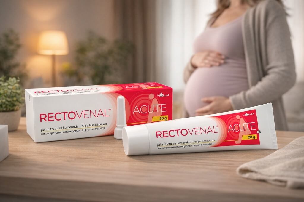 Kutija i tuba Rectovenal Acute gela za hemoroide postavljeni na drvenom stolu, dok u pozadini stoji trudnica koja rukama pridrลพava stomak u toplom, kuฤnom ambijentu