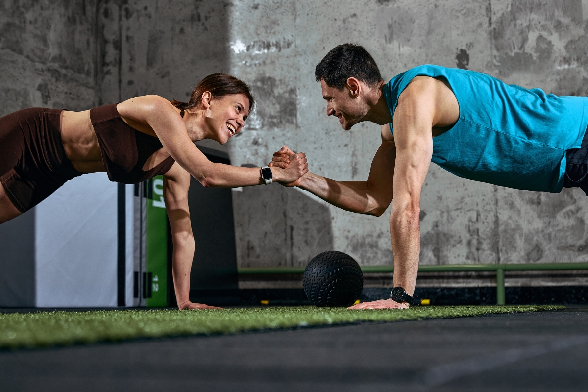 muลกkarac i devojka rade sklek u teretani i pozdravljaju se