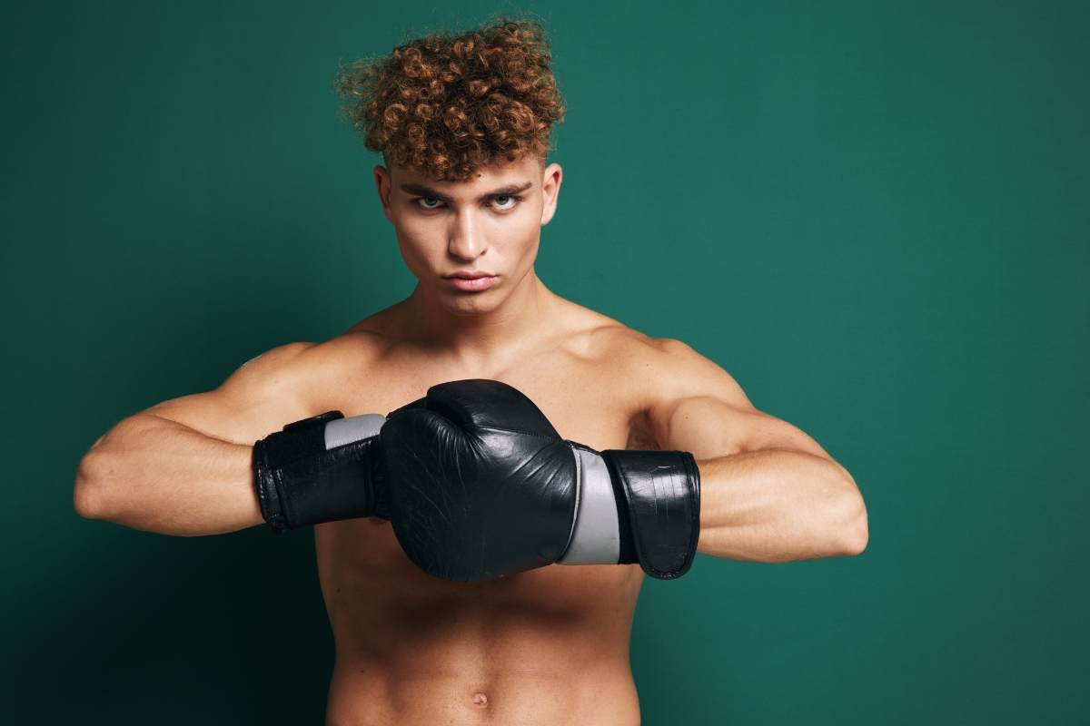 momak bez majice pozira u sportskim rukavicama