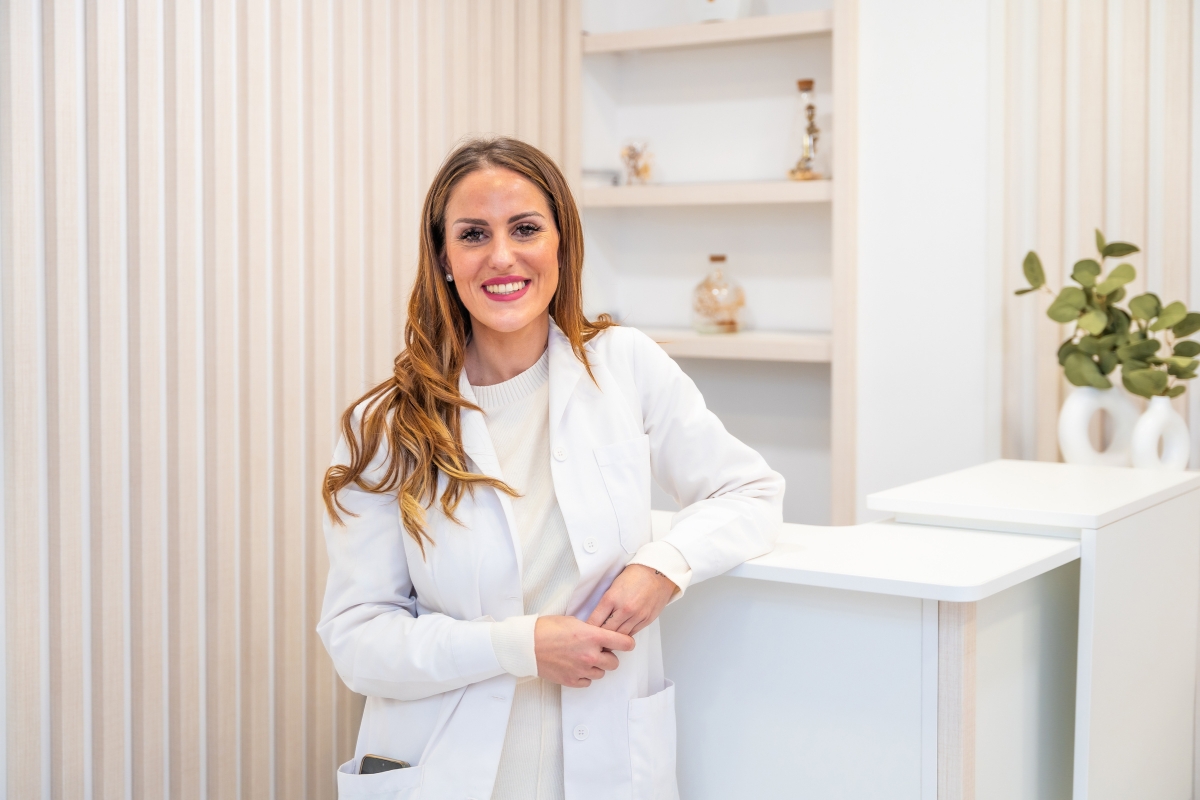 devojka beauty stručnjak, stoji naslonjena na sto i veselo se smeje